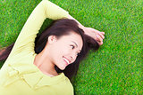 young woman lying and looking side in a meadow