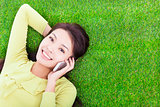 pretty girl talking over the phone in a meadow