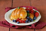 fresh croissant with berries for breakfast on vintage plate
