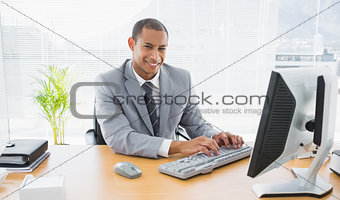 Smiling businessman using computer at office