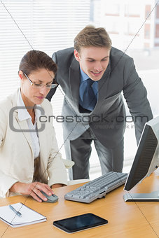 Cusiness couple using computer at office desk