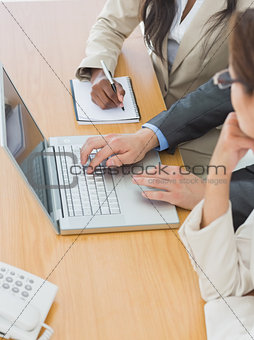Business colleagues using laptop at office desk