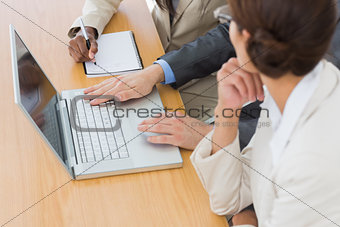 Business colleagues using laptop at desk