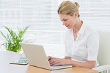 Businesswoman using laptop at desk