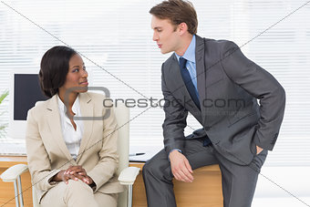 Colleagues conversing in office