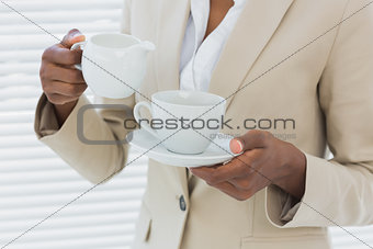 Mid section of elegant businesswoman with tea cup