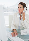 Businesswoman using computer and phone