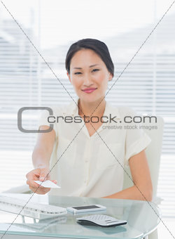 Woman handing over her business card at desk