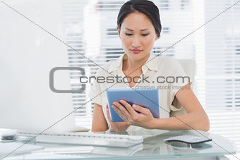 Businesswoman using digital tablet at desk