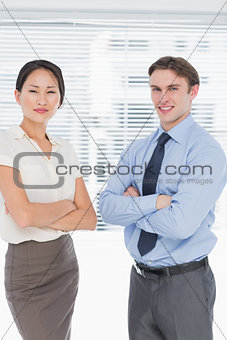 Business colleagues with arms crossed in office