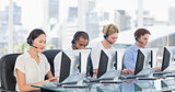 Colleagues with headsets using computers at desk