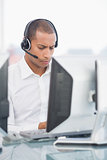 Executive with headset using computer at desk