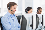 Business colleagues with headsets using computers in office