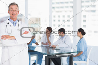 Doctor with group around table in background at hospital