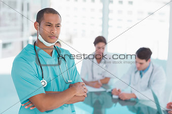Surgeon standing with group around table in hospital
