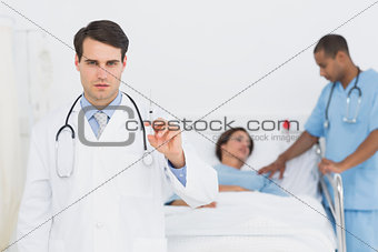 Doctor holding a syringe with patient in hospital