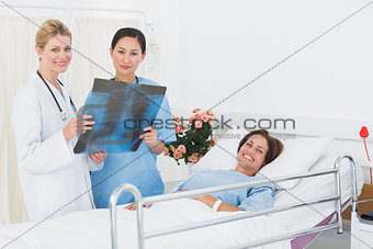 Doctors examining xray with patient in hospital