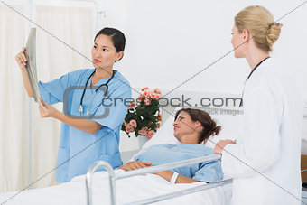 Doctors examining xray with patient in hospital