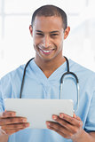 Happy handsome doctor holding digital tablet