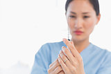 Serious female doctor holding an injection