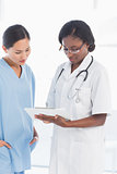 Female doctor and surgeon looking at report