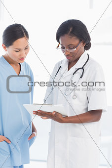 Female doctor and surgeon looking at report