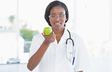 Portrait of a smiling female doctor holding an apple