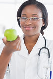 Portrait of a smiling female doctor holding an apple