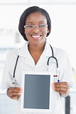 Smiling female doctor holding digital tablet
