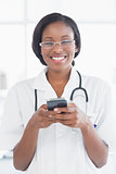 Smiling female doctor holding a mobile phone