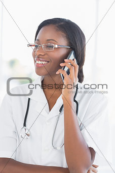 Smiling female doctor using mobile phone