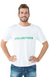 Portrait of a happy male volunteer standing with hands on hips