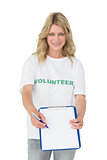 Portrait of a smiling young female volunteer holding clipboard