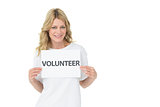 Portrait of a smiling young female volunteer holding placard