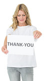 Smiling female volunteer holding thank you paper