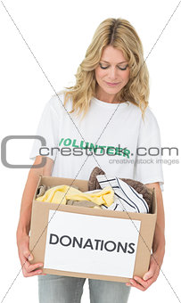 Smiling young woman carrying clothes donation