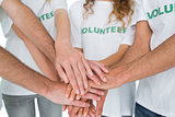Closeup mid section of volunteers with hands together