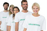 Group portrait of happy volunteers standing in a row