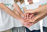 Mid section of volunteers with hands together