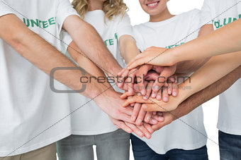 Mid section of volunteers with hands together