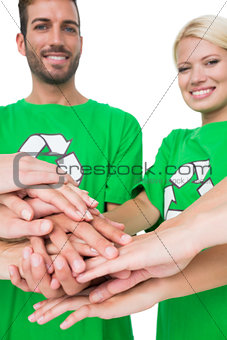 People in recycling symbol tshirts with hands together