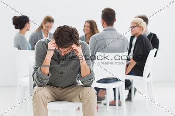 Therapy in session sitting in circle while man in foreground