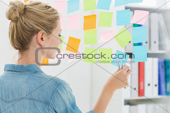 Rear view of a female artist looking at colorful sticky notes