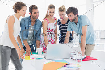 Casual business people using laptop together