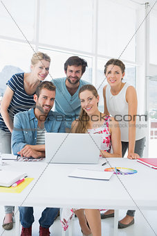 Casual business people using laptop together