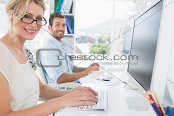 Casual young couple working on computer in office