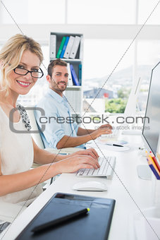 Smiling casual young couple working on computer