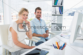 Portrait of smiling casual young couple with computer