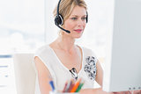 Casual woman with headset using computer