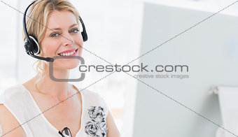 Portrait of a casual woman with headset using computer